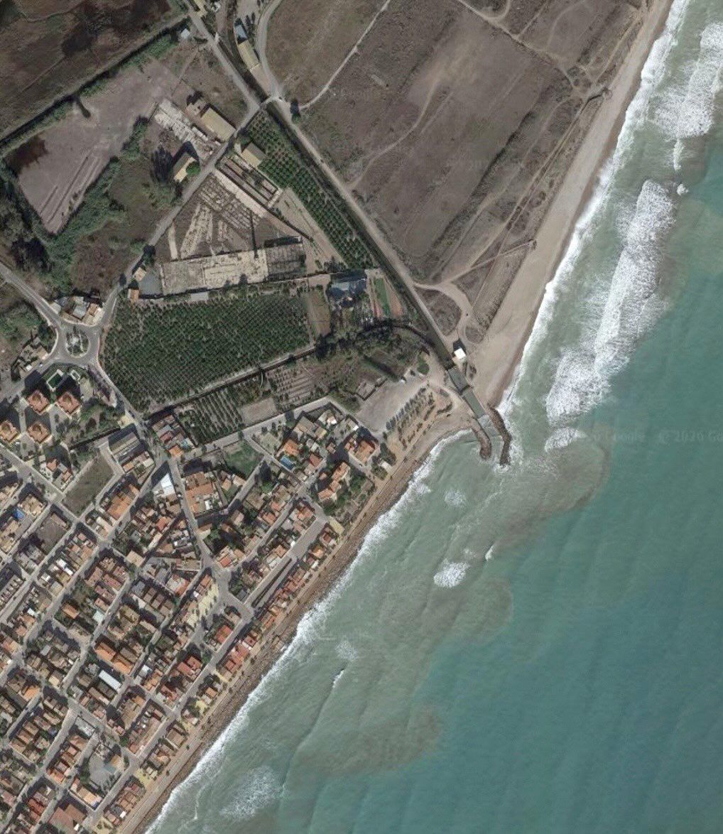 Exemple real d'acumulació d'arena a un costat d'un espigó