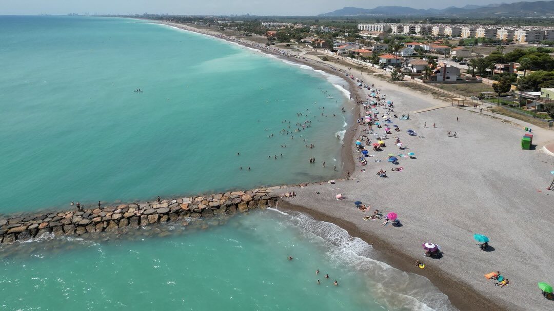 Vista aèria de la platja d'Almenara amb la mar turquesa i el poble al fons